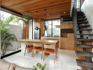 a kitchen with a wooden table and chairs at Blacksand Villas Canggu in Canggu