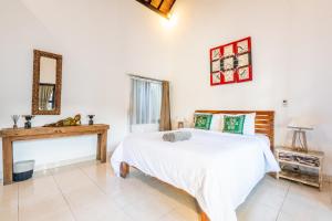 a bedroom with a white bed and a mirror at Villa Coco - Seminyak in Seminyak