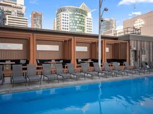 una piscina con sedie e tavoli in cima a un edificio di Deluxe CN Tower View FreeParking PrimeDT Location F1 a Toronto