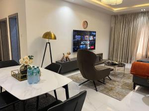 uma sala de estar com uma mesa e cadeiras e uma televisão em Gorgeous 2 Bedroom with parking inside Banana Island, Ikoyi em Lagos