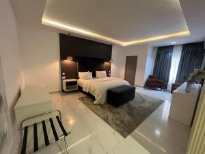 um quarto de hotel com uma cama e uma cadeira em Gorgeous 2 Bedroom with parking inside Banana Island, Ikoyi em Lagos