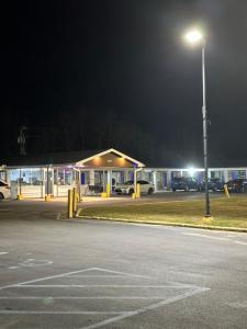 an empty parking lot with a gas station at night at Best Inn in Pike Road