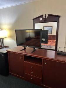 a flat screen tv on a dresser with a mirror at Best Inn in Pike Road