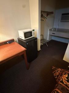 a room with a microwave on top of a table at Best Inn in Pike Road