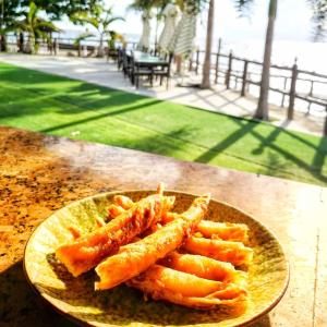 Dive and Trek Resort and Marine Sanctuary في Bauan: طبق من الطعام على طاولة مع طعام عليه
