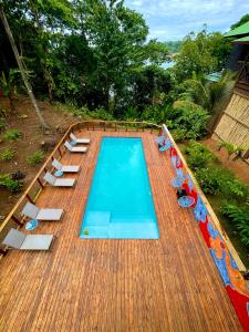 una terraza de madera con vistas a una piscina. en The Lodge at Punta Rica- Hilltop Eco-Lodge with Views & Pool en Bastimentos