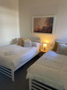 a room with two beds and a painting on the wall at 338 Paradiso Kingscliff Beach in Kingscliff