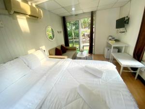 a bedroom with a large white bed and a living room at Sleep Home Khaoyai in Pak Chong +31 photos