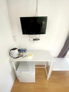 a white desk with a flat screen tv on a wall at Sleep Home Khaoyai in Pak Chong