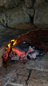 a fire in a stone oven with some food at La Escondida in Tafí del Valle +7 photos