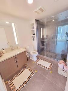 uma casa de banho com um chuveiro, um WC e um lavatório. em Stunning 1bed Apartment Downtown 1 min to Petco Park Convention Center em San Diego