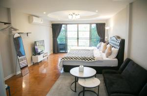 a bedroom with a large bed and a living room at Hello Host (Top View) in Chiang Mai
