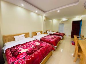 2 Betten in einem Hotelzimmer mit roter Bettwäsche in der Unterkunft Kim Thoa Hotel Trung Khanh in Bản Piên