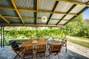 un patio con mesa y sillas bajo un techo en The Barn At 2111- Hastings Holiday Home, en Hastings