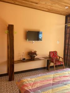 1 dormitorio con escritorio y TV en la pared en Nhà của Nếp en Plei Brel (2)