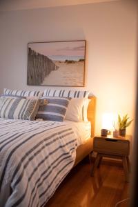 a bedroom with a bed and a picture of the beach at Sea View Guest House in Hobart