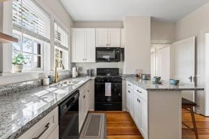 a kitchen with white cabinets and black appliances at Best Location In San Marco! Walkable shopping&fun! in Jacksonville