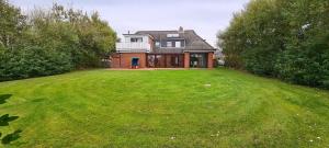 a large house with a large grassy yard at Seesternchen-FeWo-Nr-1-EG in Böhl