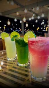 three cocktails sitting on a glass table at Seven Inn Hotel in Medellín