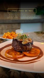 a plate of food with a steak and some carrots at Seven Inn Hotel in Medellín