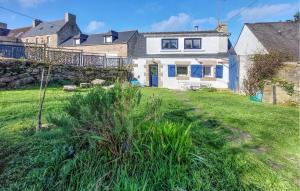 a white house with blue windows and a yard at 2 Bedroom Lovely Home In Pleumeur-Bodou in Pleumeur-Bodou +18 photos