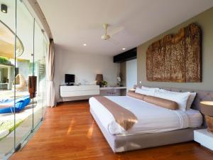 1 dormitorio con 1 cama blanca grande y puerta corredera de cristal en Villa Toraja by LifestyleRetreats, en Canggu