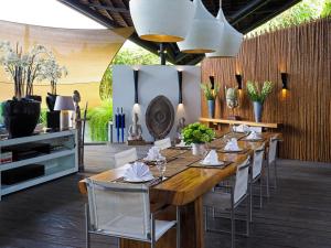 una sala da pranzo con un lungo tavolo in legno e sedie di Villa Toraja by LifestyleRetreats a Canggu