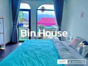 ein großes Bett in einem Zimmer mit einem großen Fenster in der Unterkunft Bin House - Mộc Châu in Mộc Châu