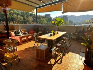 a patio with a table and chairs on a balcony at Dreamy Nomads Hostel日月潭背包客 in Yuchi