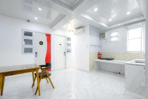 a white kitchen with a desk and a red wall at Urbanview Hotel Kota Tua Jakarta in Jakarta