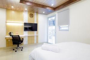 um quarto com uma cama, uma secretária e uma cadeira em Urbanview Hotel Kota Tua Jakarta em Jakarta