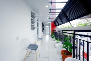 een hal met stoelen en planten in een gebouw bij Urbanview Hotel Kota Tua Jakarta in Jakarta