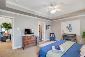 a bedroom with a blue bed and a television at 8min Texas A&M 1 King Beds firepit GriddleGrill in College Station