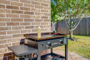 a barbecue grill with a bottle on it next to a brick wall at 8min Texas A&M 1 King Beds firepit GriddleGrill in College Station +64 photos