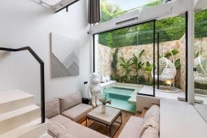 un soggiorno con divano e una piscina di Alex Villas Complex N3 a Canggu