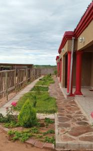 un trottoir à côté d'un bâtiment avec clôture dans l'établissement Lormasol Mews Guesthouse, à Serowe