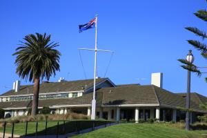 uma bandeira no topo de uma casa com uma palmeira em The Victoria Golf Club em Melbourne