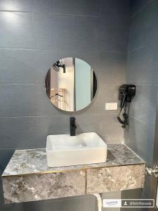 a bathroom with a white sink and a mirror at Bin House - Mộc Châu in Mộc Châu