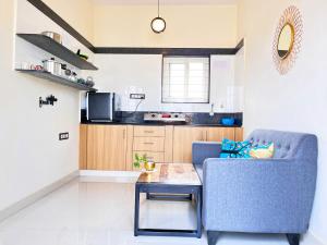 a living room with a blue couch and a table at ILYA SERVICED APARTMENTS in Bangalore