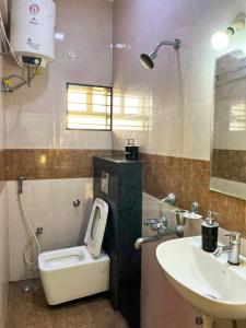 a bathroom with a toilet and a sink at ILYA SERVICED APARTMENTS in Bangalore