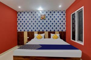 um quarto com uma cama com uma parede azul e vermelha em SPOT ON Hotel C S Tower em Lucknow