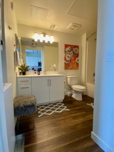 a bathroom with a sink and a toilet and a mirror at Ely on Fremont in Las Vegas