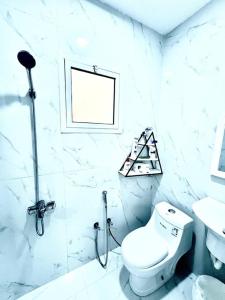 uma casa de banho branca com um WC e um lavatório em Brand new apartment em Al Fayşalīyah