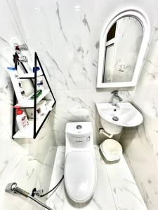 uma casa de banho em mármore branco com um WC e um lavatório em Brand new apartment em Al Fayşalīyah