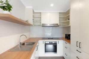 a kitchen with white cabinets and a sink at Dunsmore Lodge in Cowes +8 photos