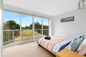 a bedroom with a bed and a large window at Dunsmore Lodge in Cowes