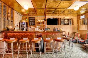 um bar com bancos de madeira num restaurante em The Twin Lions: Bespoke Travel Lodge w/ Speakeasy* em Chicago
