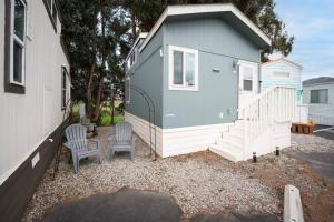 a tiny house with two chairs and a staircase at Coastal Tiny House 2 Queen Beds low loft in San Luis Obispo