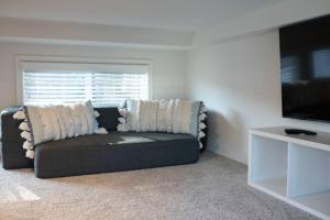 uma sala de estar com um sofá e uma televisão de ecrã plano em Coastal Tiny House 2 Queen Beds low loft em San Luis Obispo
