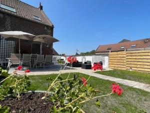 un cortile con patio attrezzato con sedie e ombrellone di Gîte familial de charme avec jardin, proche de sentiers et activités nature, tout inclus ! - FR-1-510-187 a Wallers